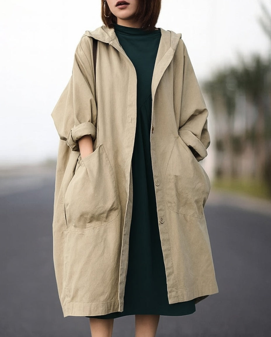 Beige oversized regenjas met capuchon, gedragen door vrouw op straat | Boutique Moda