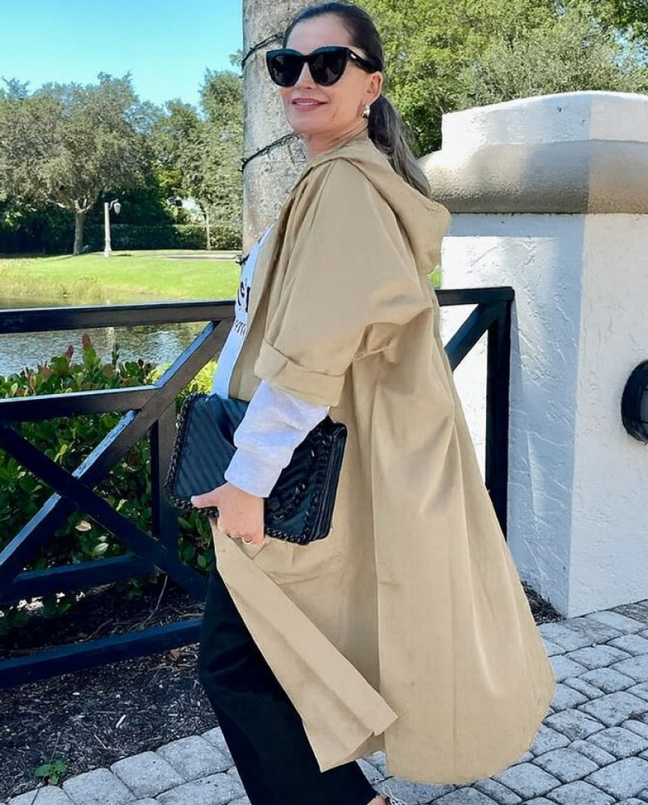 Vrouw draagt beige oversized regenjas met capuchon, buiten wandelend | Boutique Moda