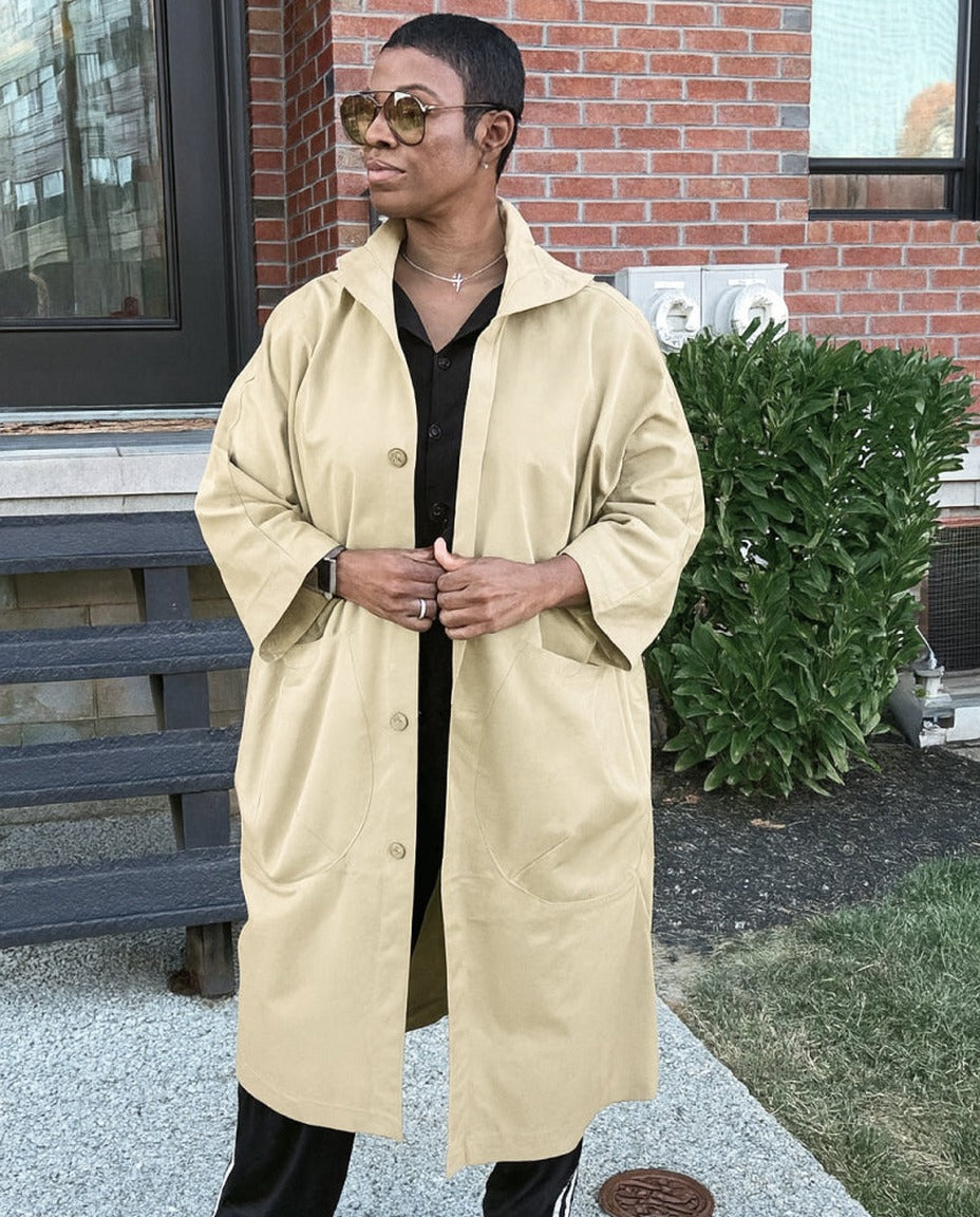 Beige oversized regenjas met knopen, gedragen door vrouw met zonnebril | Boutique Moda