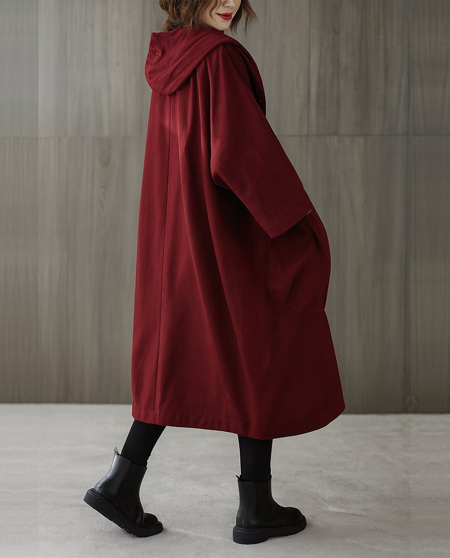 Bordeauxrode oversized regenjas met capuchon, gedragen door vrouw met laarzen | Boutique Moda