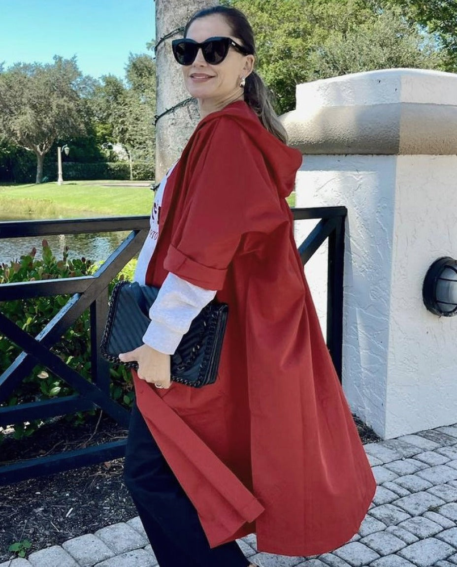 Rode oversized regenjas met capuchon, gedragen door vrouw buiten staand | Boutique Moda