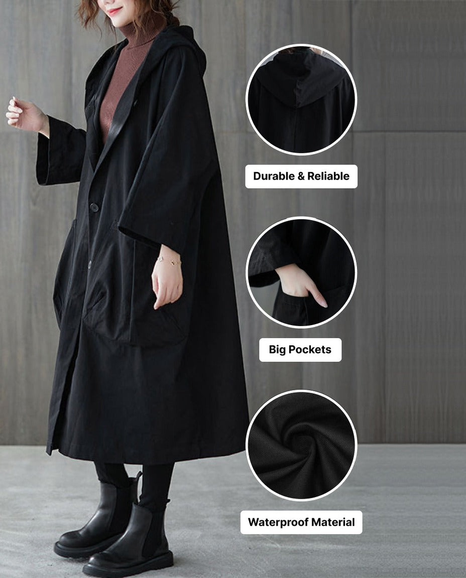Zwarte oversized regenjas met capuchon en grote zakken, gedragen door model | Boutique Moda