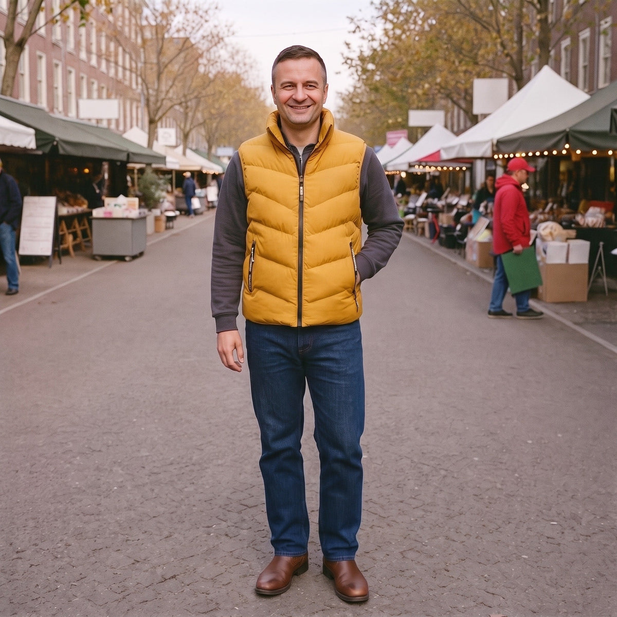 Man draagt mosterdgele gewatteerde puffervest met grijze mouwen op straatmarkt | Boutique Moda