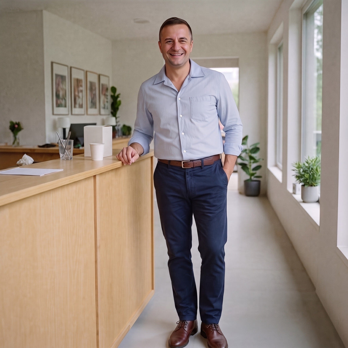Man draagt marineblauwe stretch chino met lichtgrijs overhemd, kantooromgeving | Boutique Moda