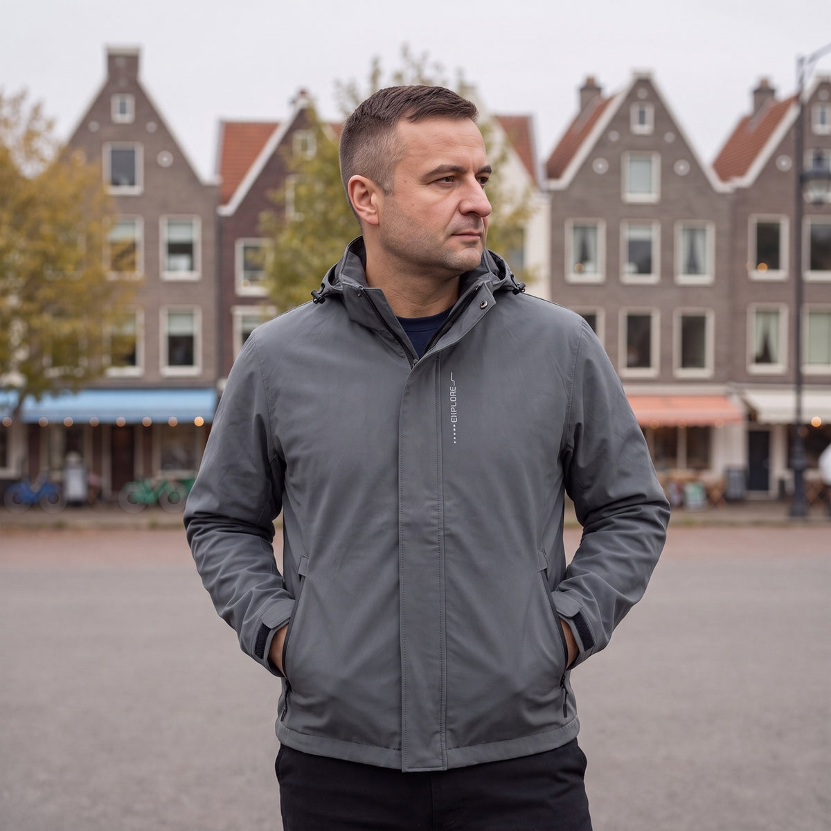 Man draagt de grijze regenjas met capuchon