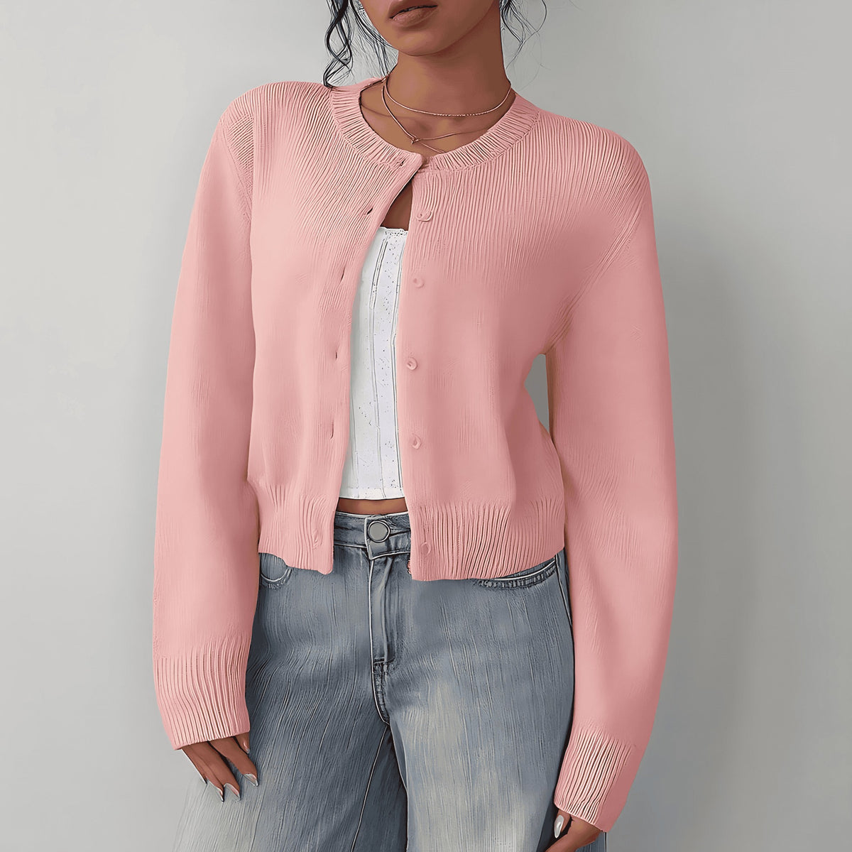 Roze kort damesvest met knoopsluiting, gedragen op een spijkerbroek | Boutique Moda