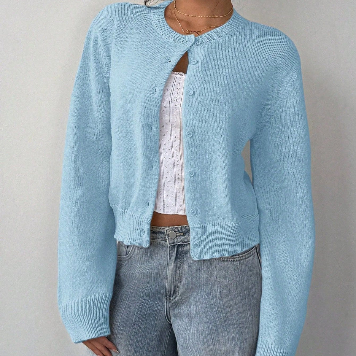 Lichtblauw kort damesvest met knoopsluiting, gedragen op een spijkerbroek | Boutique Moda