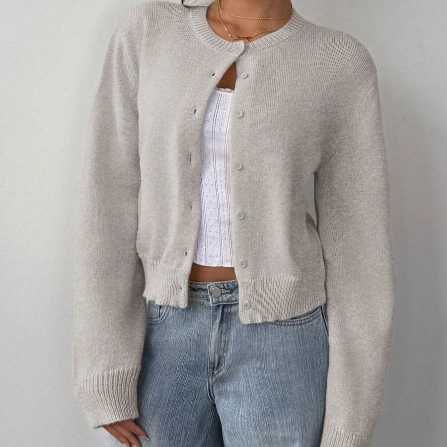 Lichtgrijs kort damesvest met knoopsluiting, gedragen op een spijkerbroek | Boutique Moda