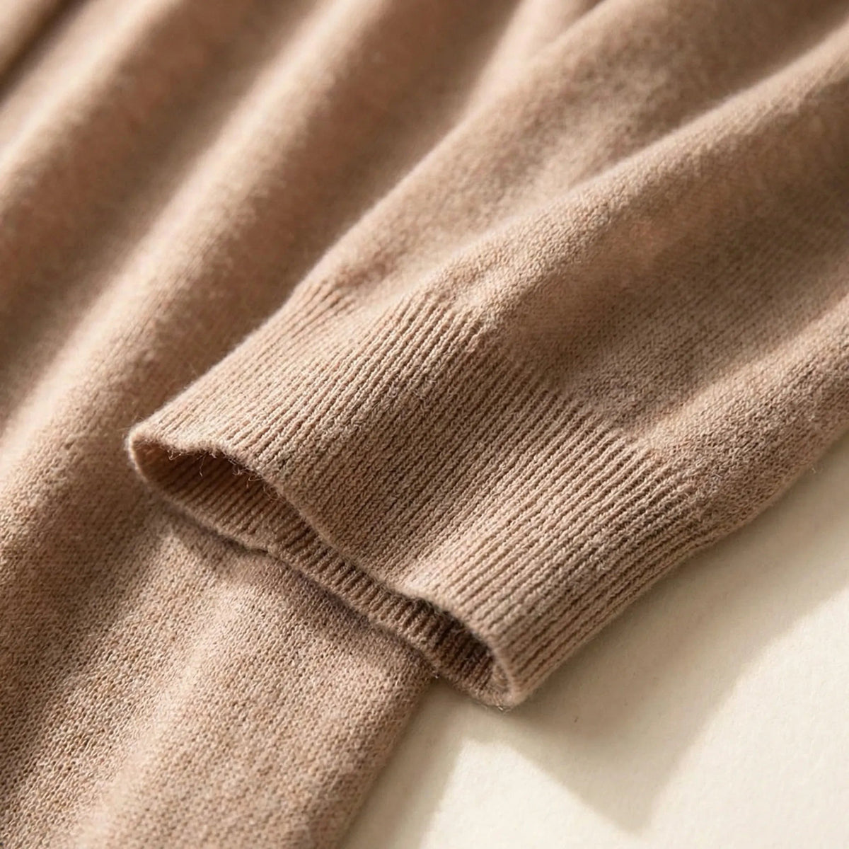 Close-up van het fijne breisel en het geribde mouwboordje in camel | Boutique Moda