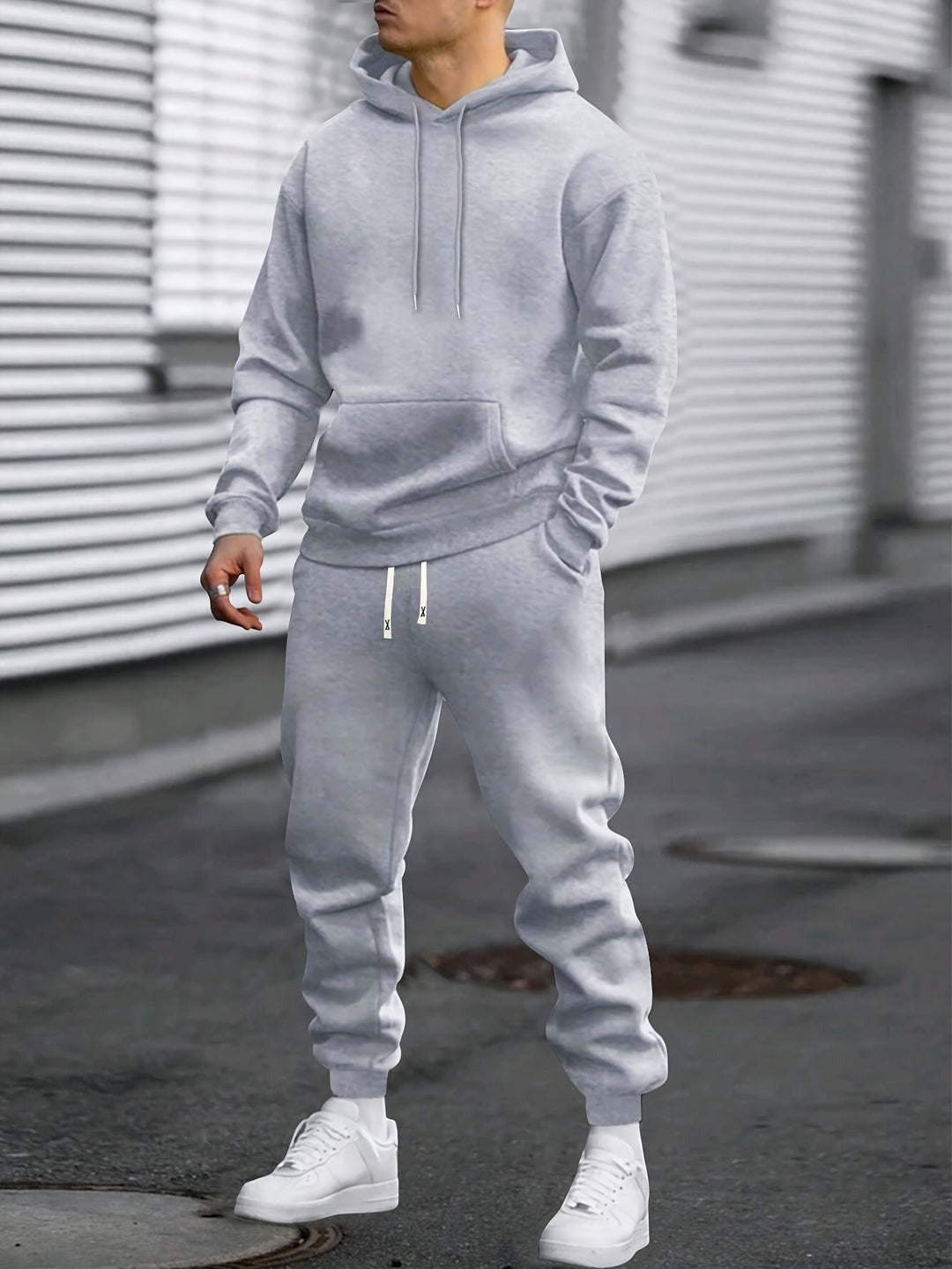 Man in een grijze hoodie en bijpassende joggingbroek op straat | Boutique Moda