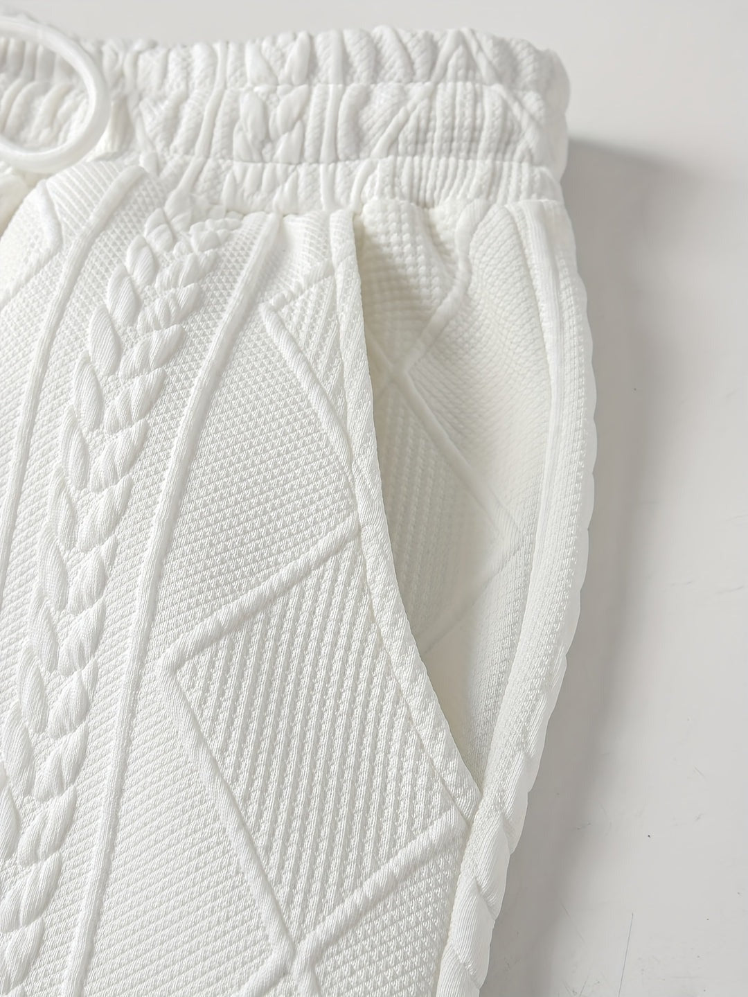 Close-up van de tailleband, het koord en de steekzak van de joggingbroek met kabelpatroon | Boutique Moda