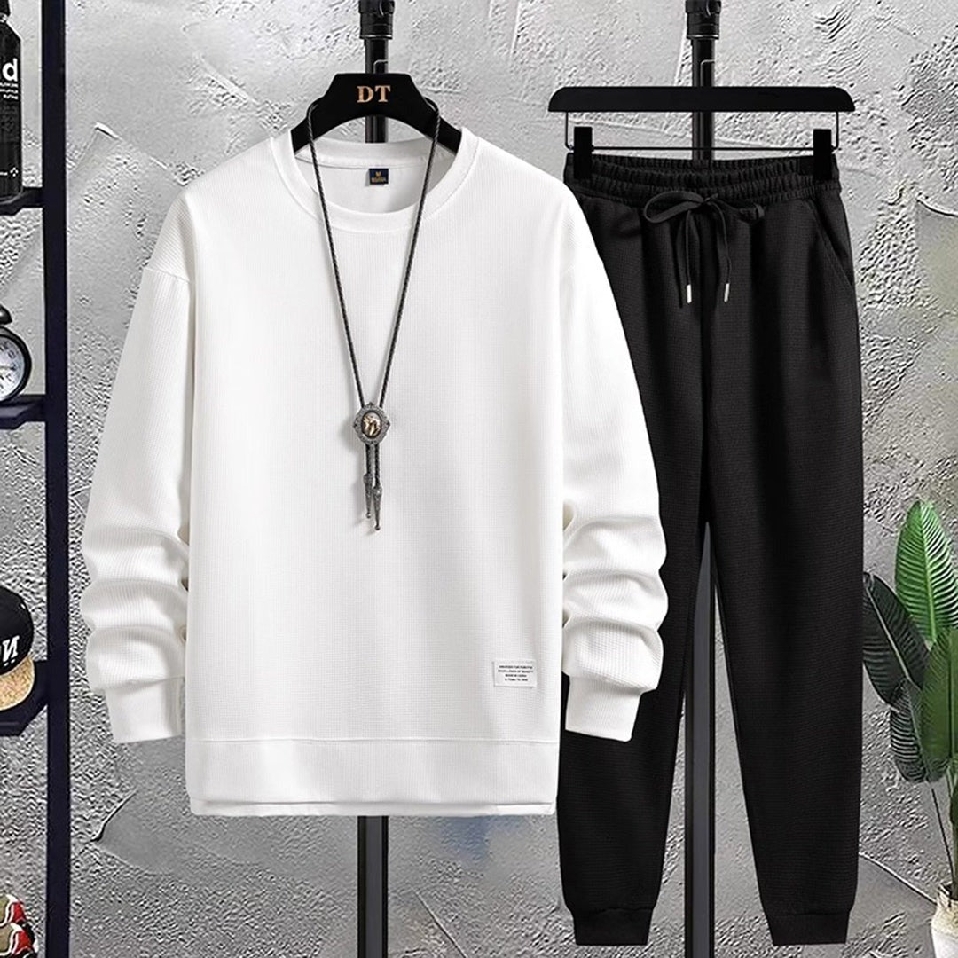 Witte sweater met wafelstructuur en zwarte joggingbroek aan hangers | Boutique Moda