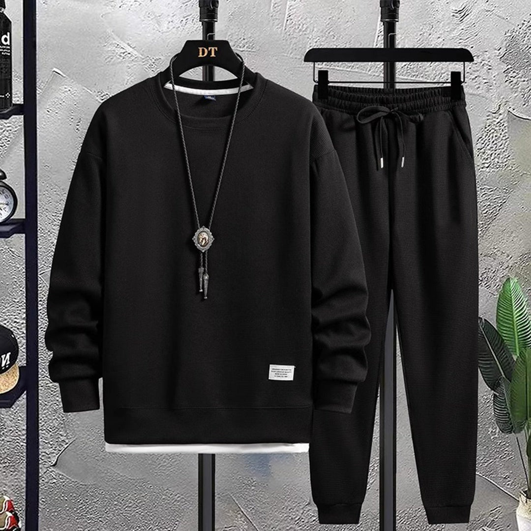 Zwarte sweater en bijpassende joggingbroek aan hangers | Boutique Moda