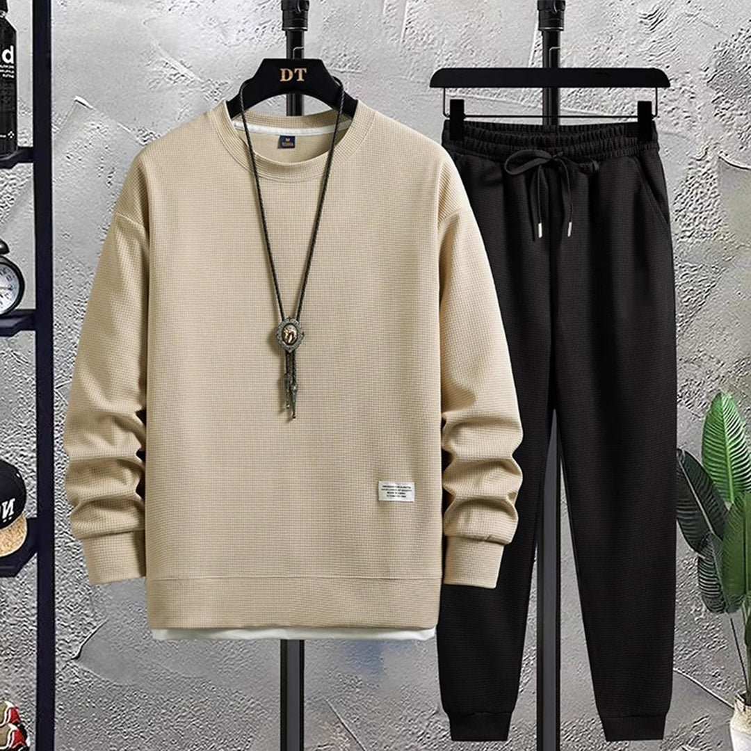 Beige sweater met wafelstructuur en zwarte joggingbroek aan hangers | Boutique Moda