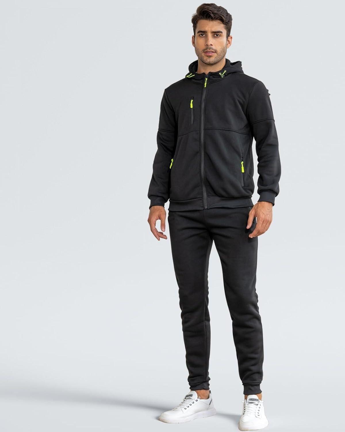 Man in een zwarte ritshoodie en joggingbroek met neongroene ritstrekkers, voorkant | Boutique Moda