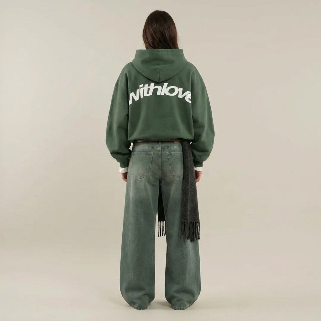 Vrouw in een groene oversized hoodie met een grote rugprint, achterkant | Boutique Moda