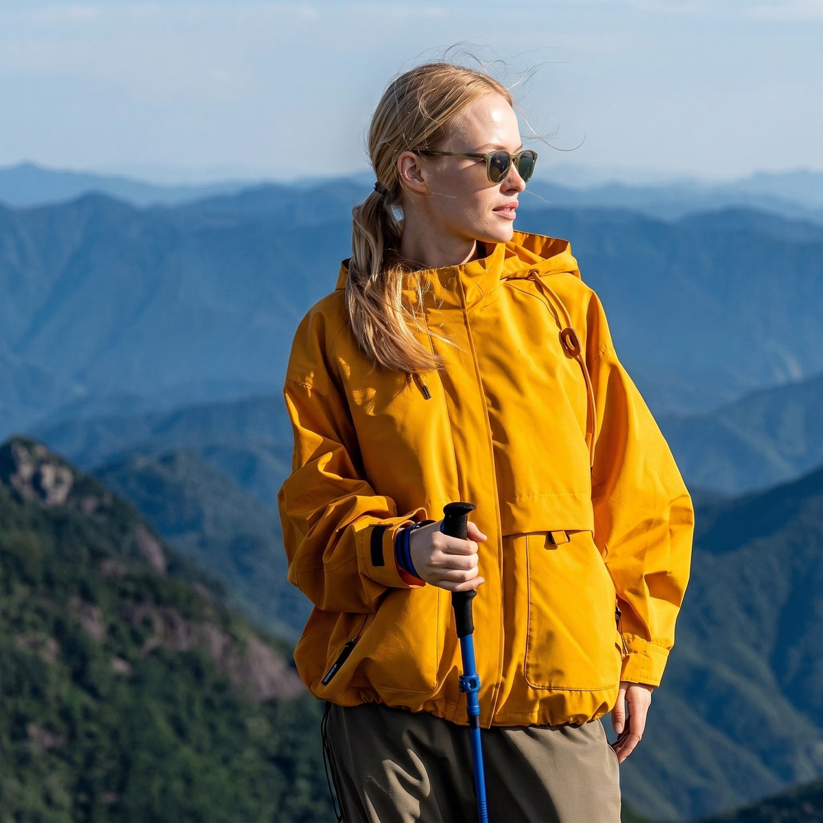 Oranje regenjas tijdens een bergwandeling met wandelstok | Boutique Moda