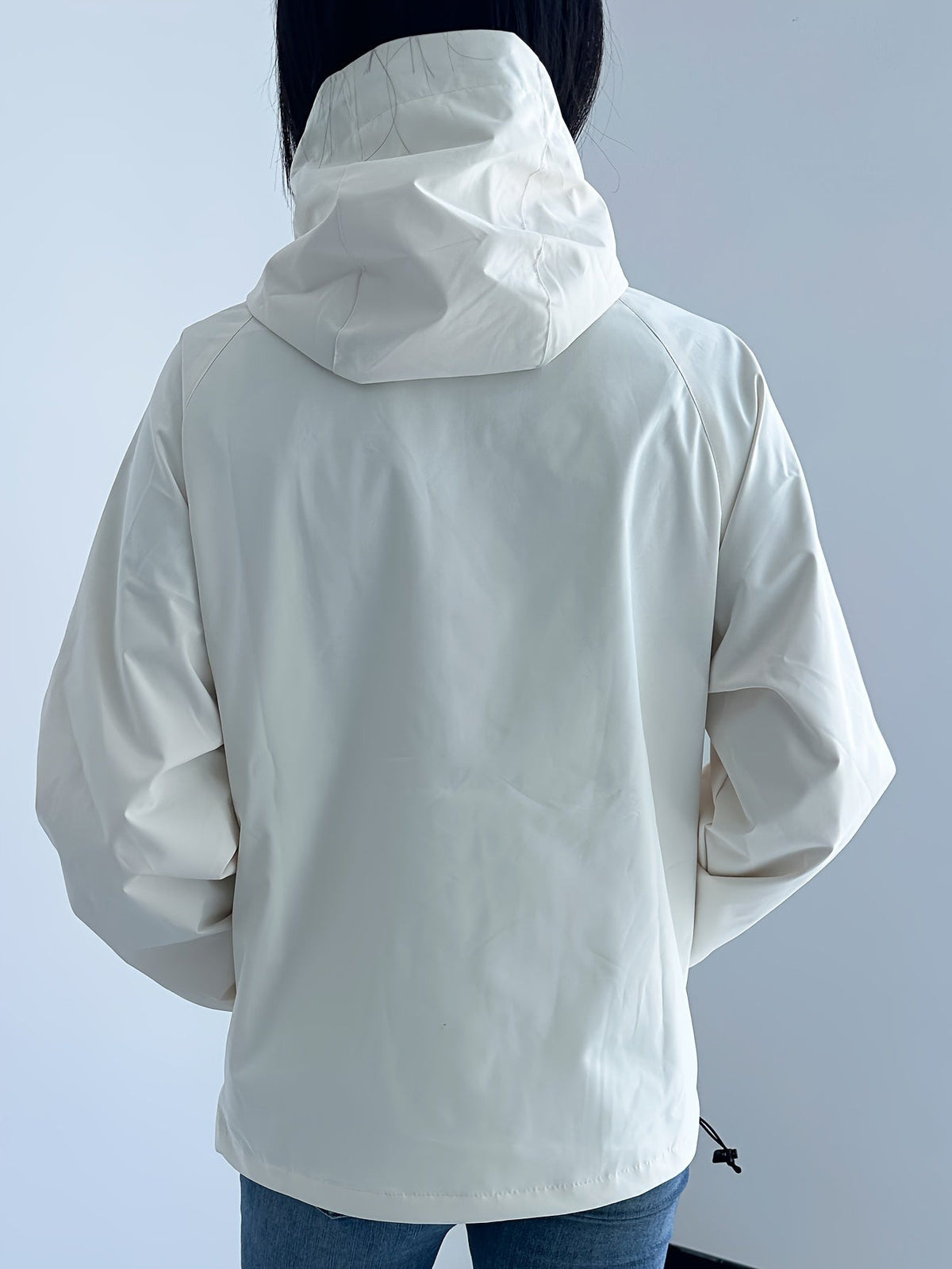Achterkant van de ivoorkleurige regenjas met capuchon | Boutique Moda