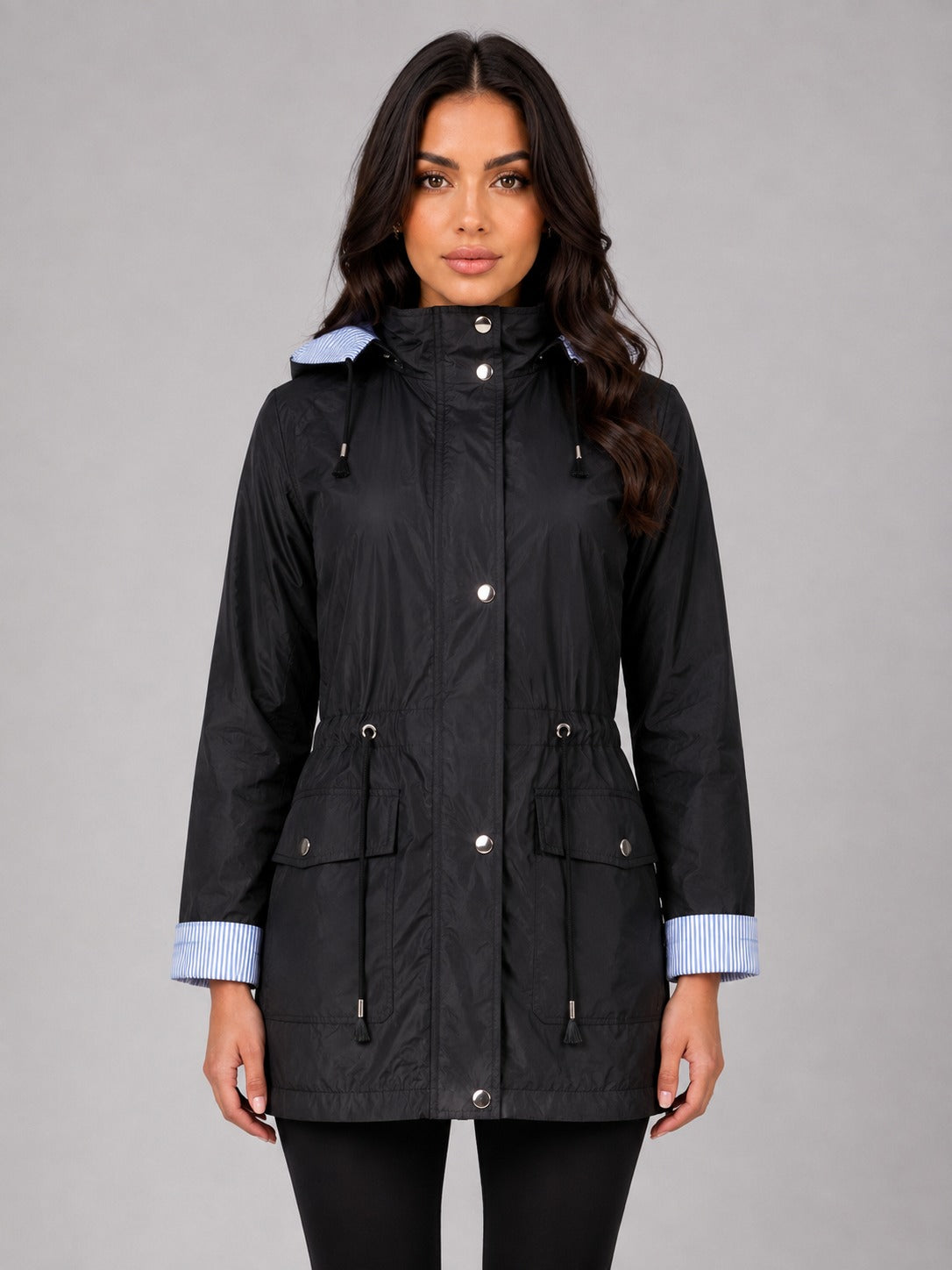 Zwarte regenjas met capuchon, taillekoord en gestreepte omgeslagen manchetten | Boutique Moda