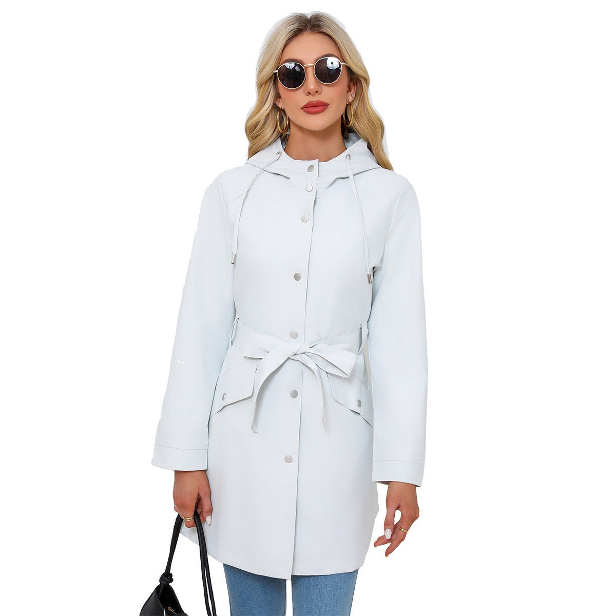 Lichtgrijze trenchcoat met capuchon, dicht met de strikceintuur, met zonnebril | Boutique Moda