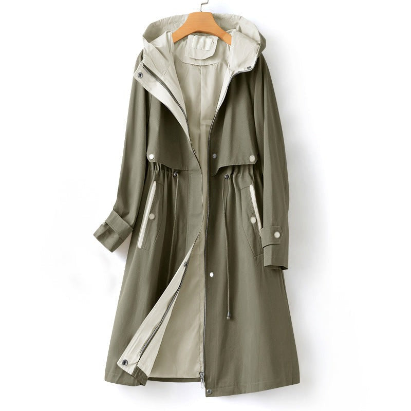 Olijfgroene trenchcoat met capuchon, trekkoord in de taille en beige binnenbeleg, aan een kledinghanger | Boutique Moda
