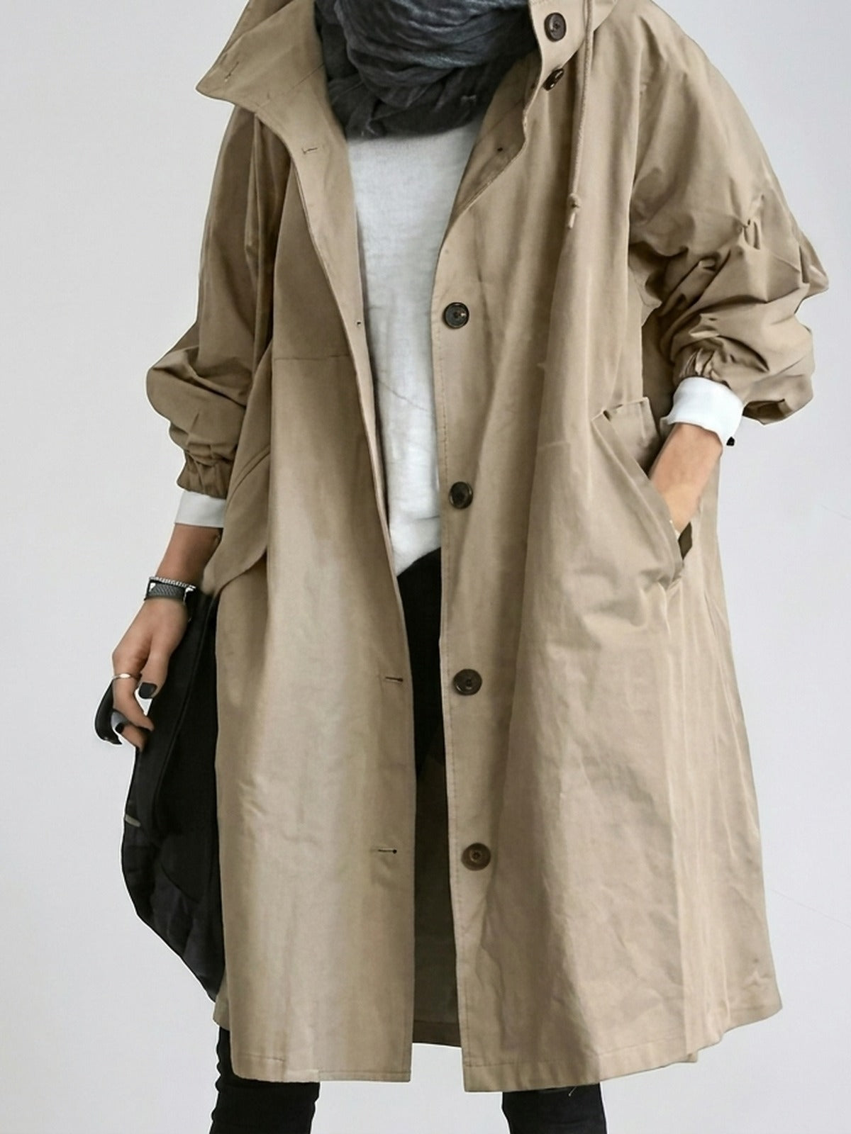 Trenchcoat met capuchon in beige, open gedragen over een wit shirt | Boutique Moda