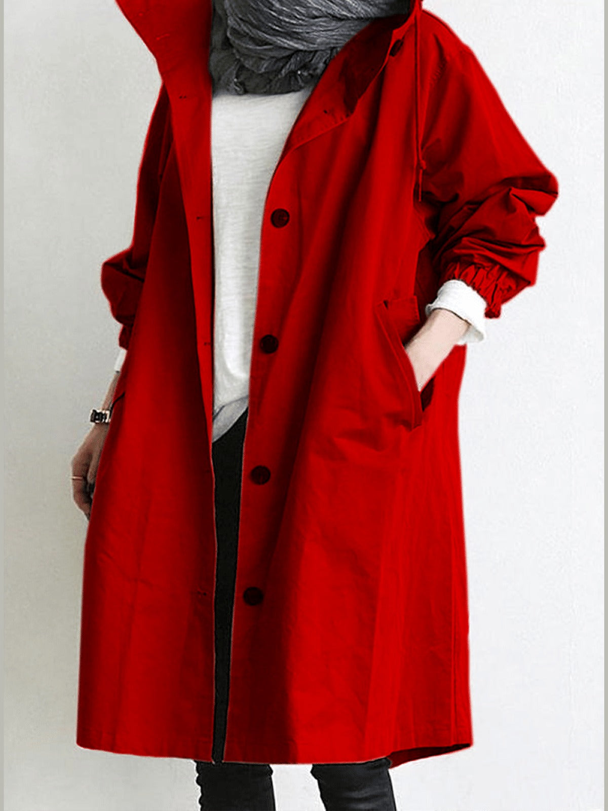 Trenchcoat met capuchon in rood, open gedragen over een wit shirt | Boutique Moda