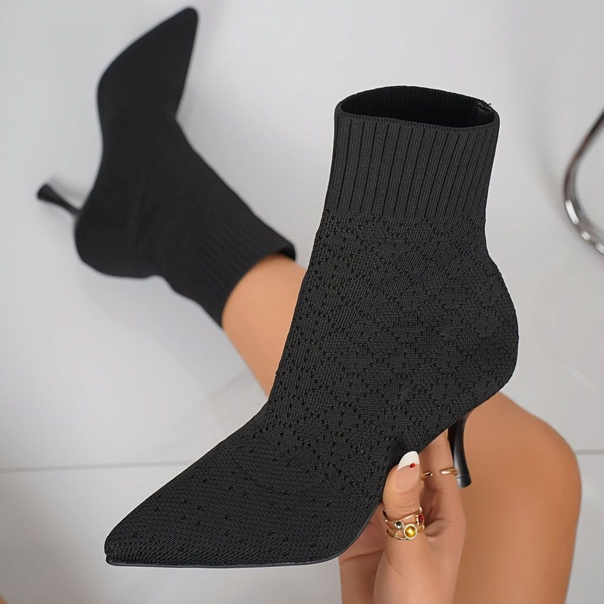 Zwarte gebreide sock boots met naaldhak aan de voet