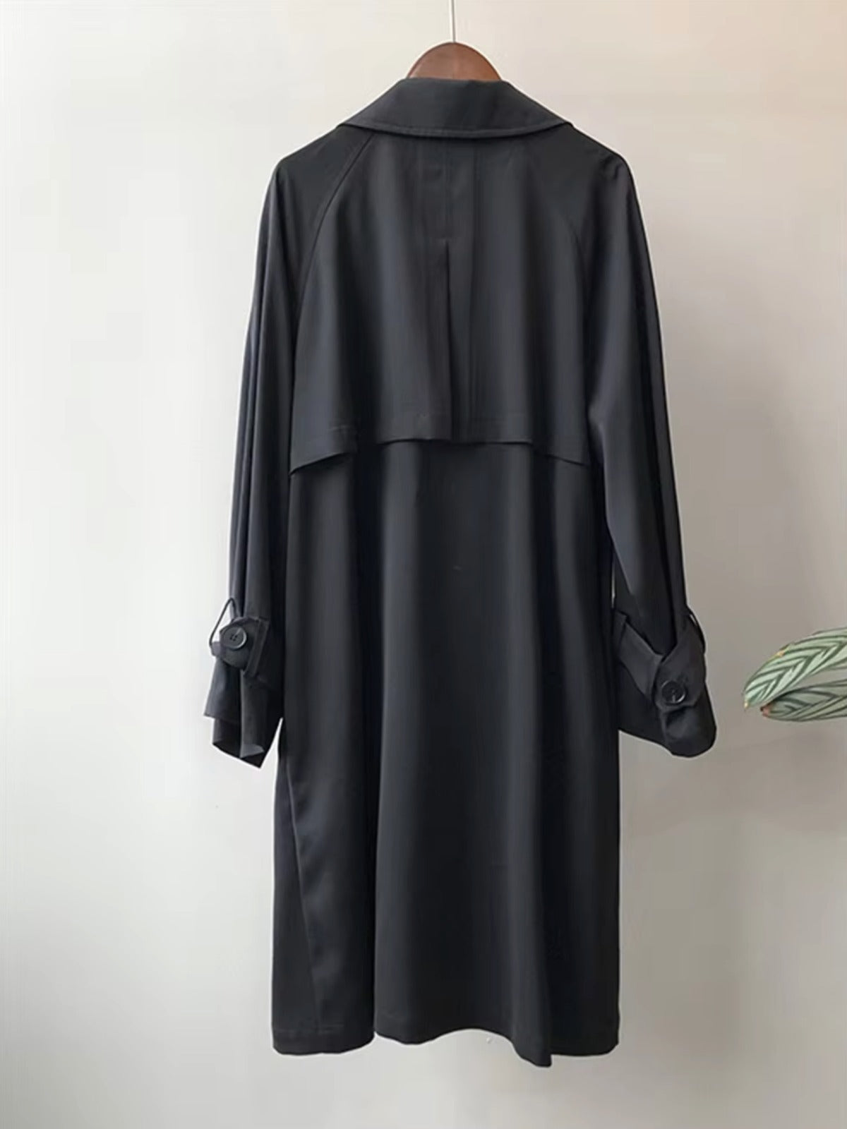 Achterkant van de zwarte trenchcoat met stormklep | Boutique Moda