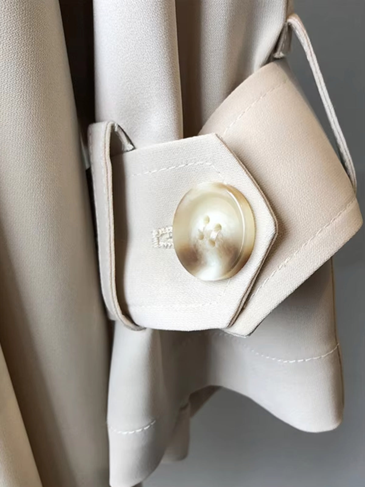 Close-up van de knoop aan de mouw | Boutique Moda