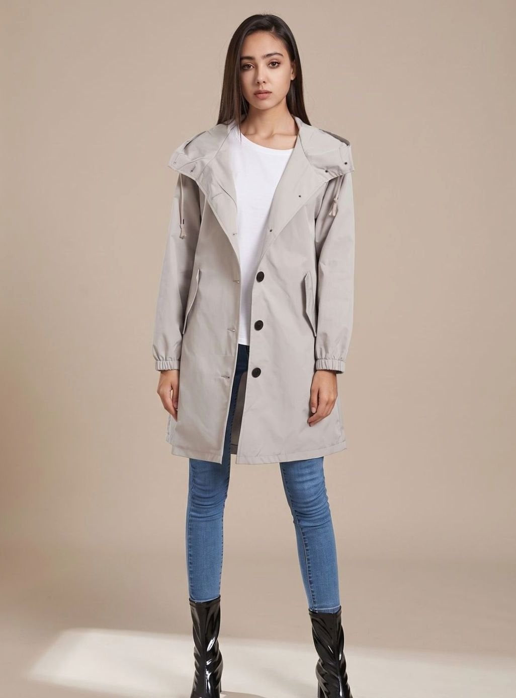 Grijze trenchcoat met capuchon op een jeans en laarzen | Boutique Moda