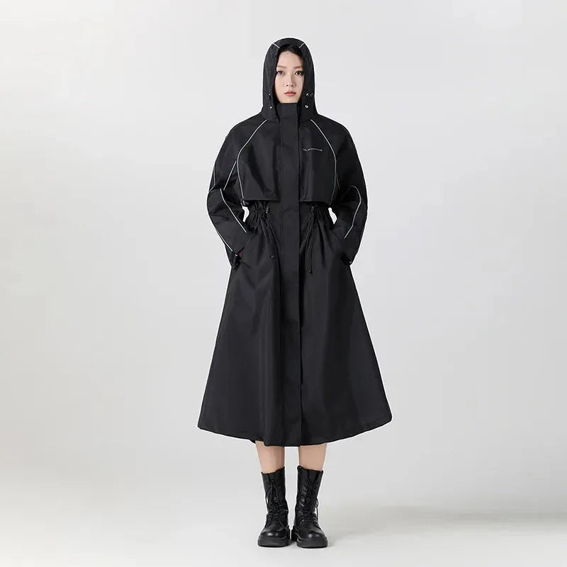 Vrouw in een lange zwarte oversized regenjas met capuchon