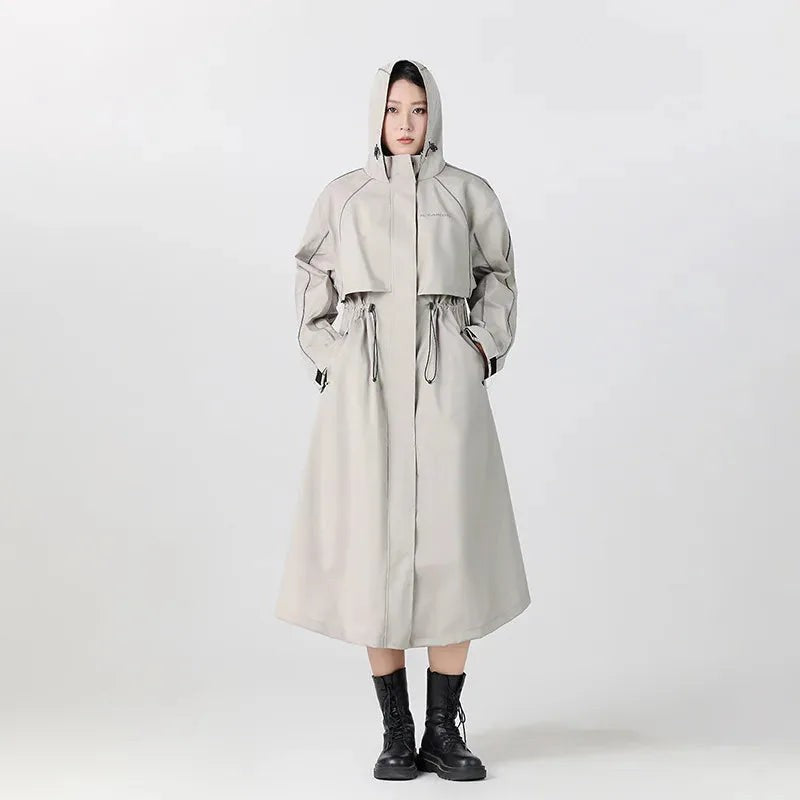 Vrouw in een lange beige regenjas met capuchon