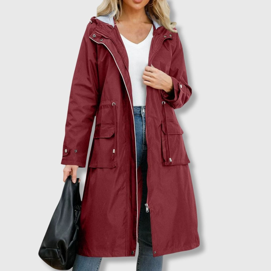 Bordeaux lange waterdichte regenjas met capuchon, taillekoord en klepzakken | Boutique Moda