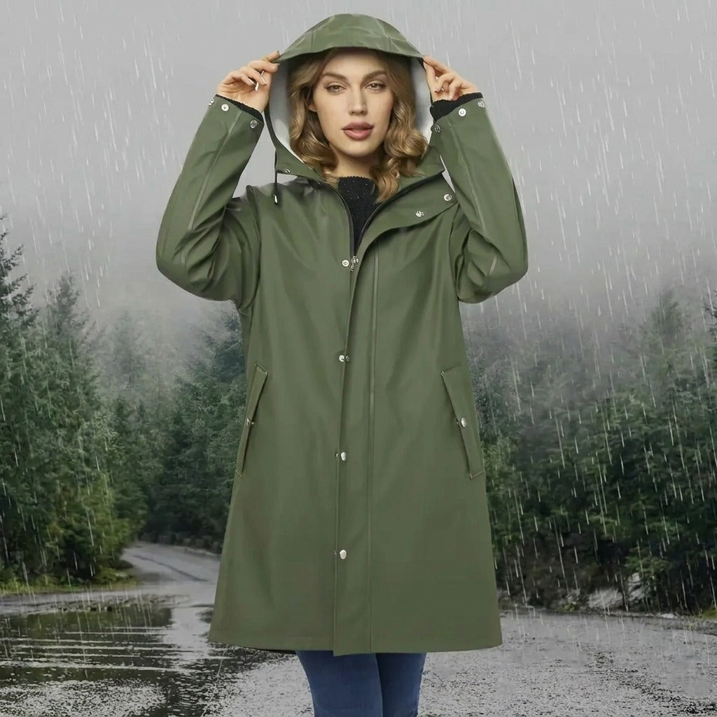 Lange waterdichte regenjas in groen met capuchon, buiten gedragen in de regen | Boutique Moda