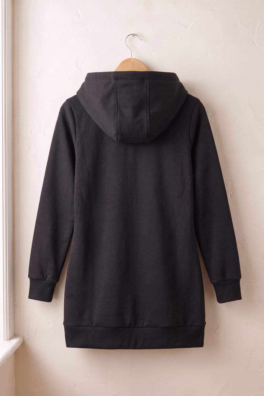Zwarte hoodie aan een hanger, achterkant