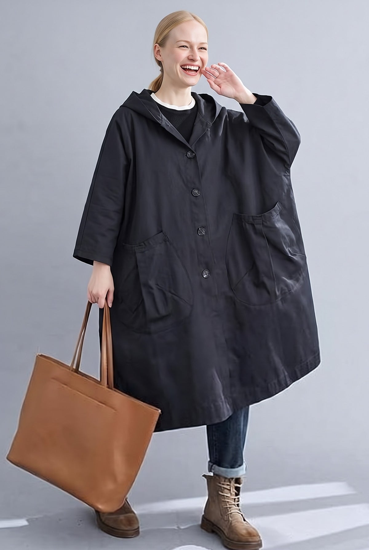 Zwarte lange oversized jas met een bruine tas | Boutique Moda