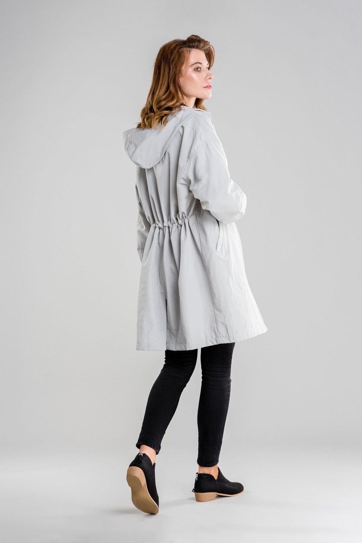 Achterkant van de ijsgrijze regenjas met capuchon en trekkoord in de taille | Boutique Moda
