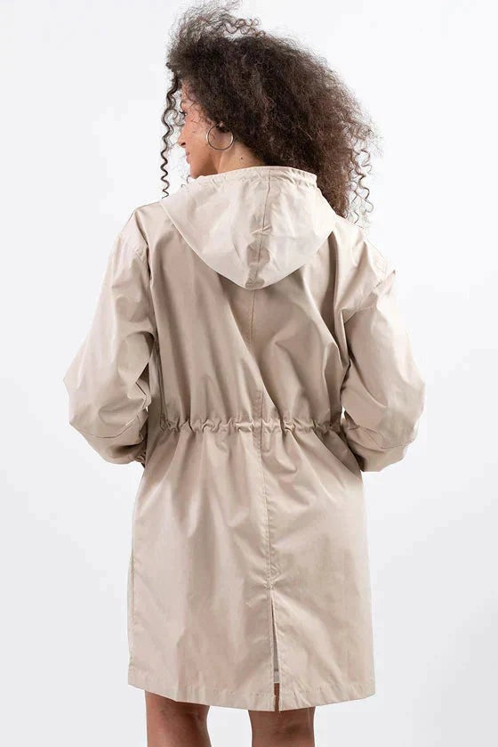 Achterkant van de beige regenjas met trekkoord in de taille en split | Boutique Moda