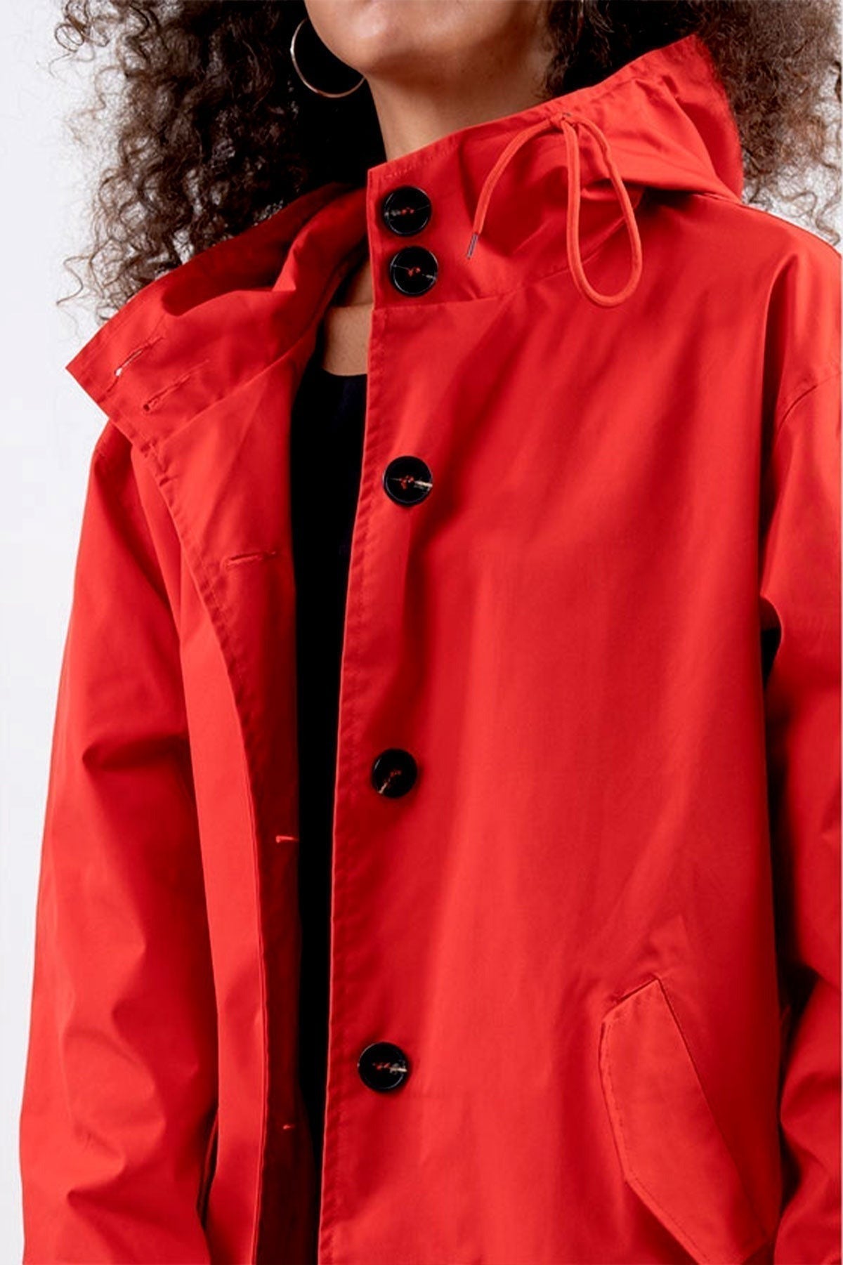Close-up van de rode regenjas: koord van de capuchon en grote knopen | Boutique Moda