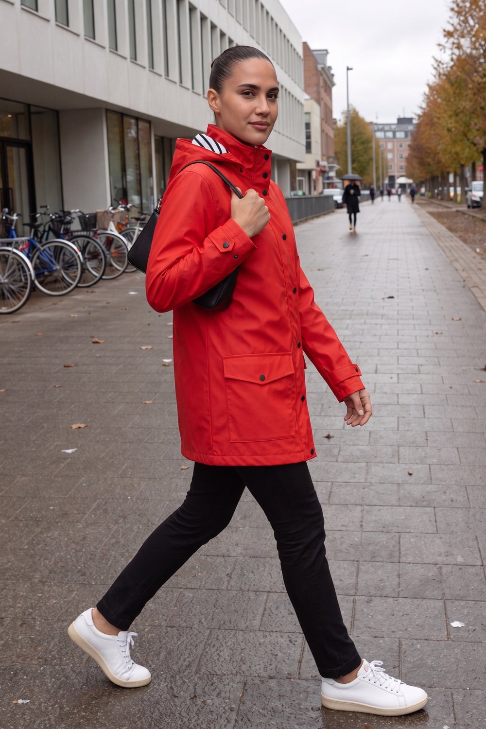 Vrouw in een rode regenjas met capuchon in Rotterdam