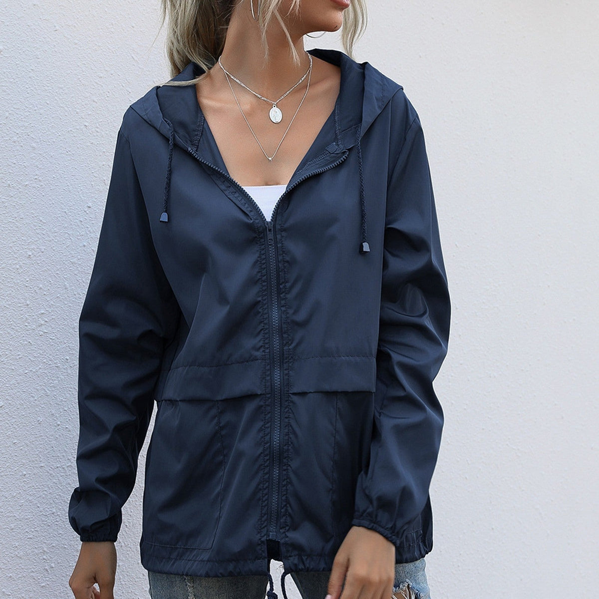 Marineblauwe lichte waterdichte regenjas met capuchon en koord aan de zoom | Boutique Moda