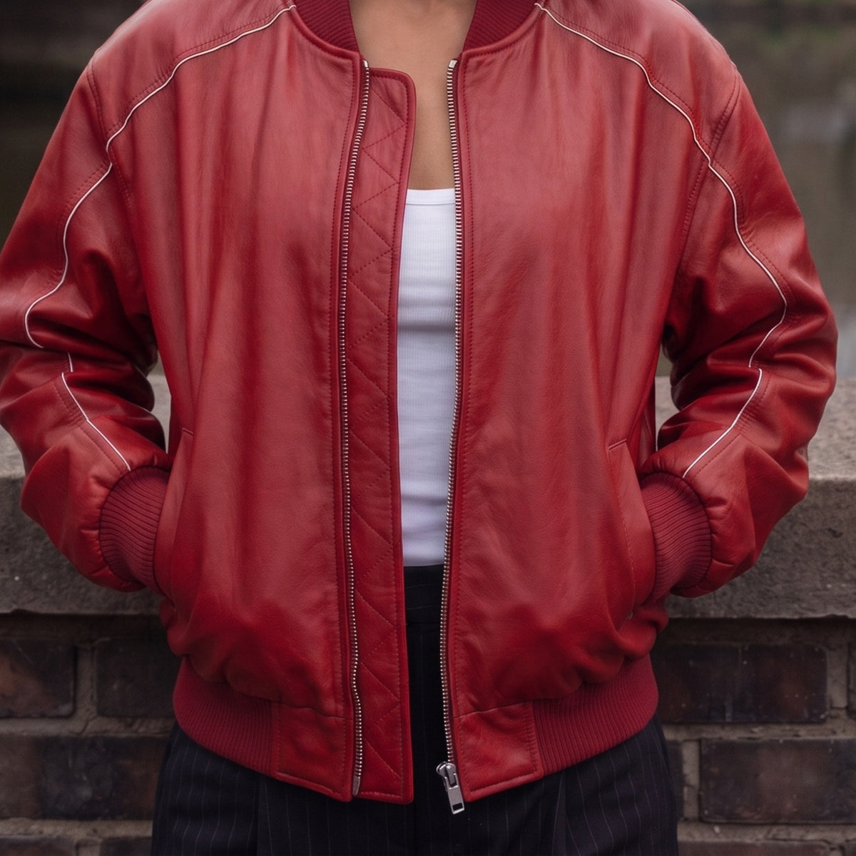 Rood bomberjack van imitatieleer open over een witte top | Boutique Moda