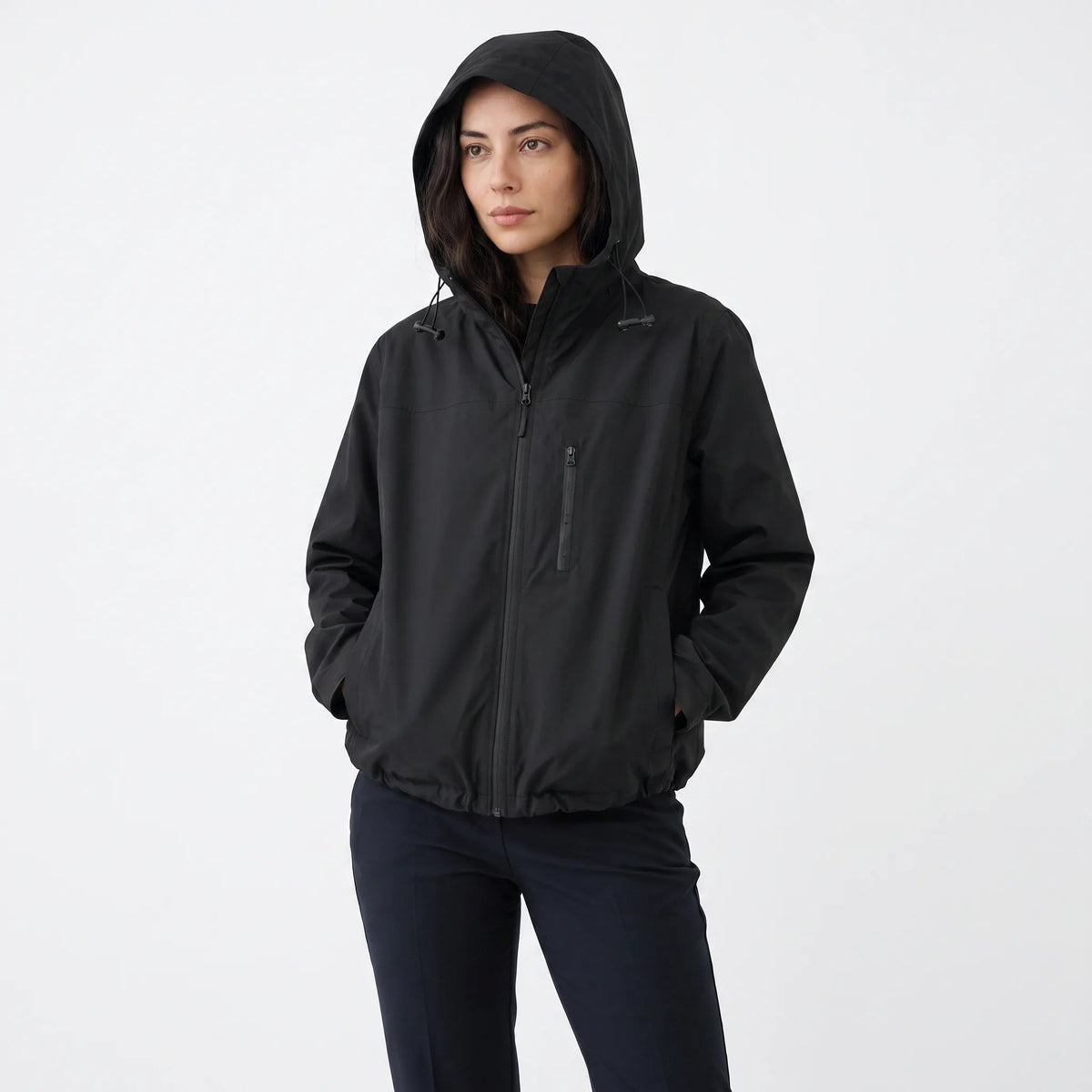 Zwarte korte regenjas met de capuchon op | Boutique Moda