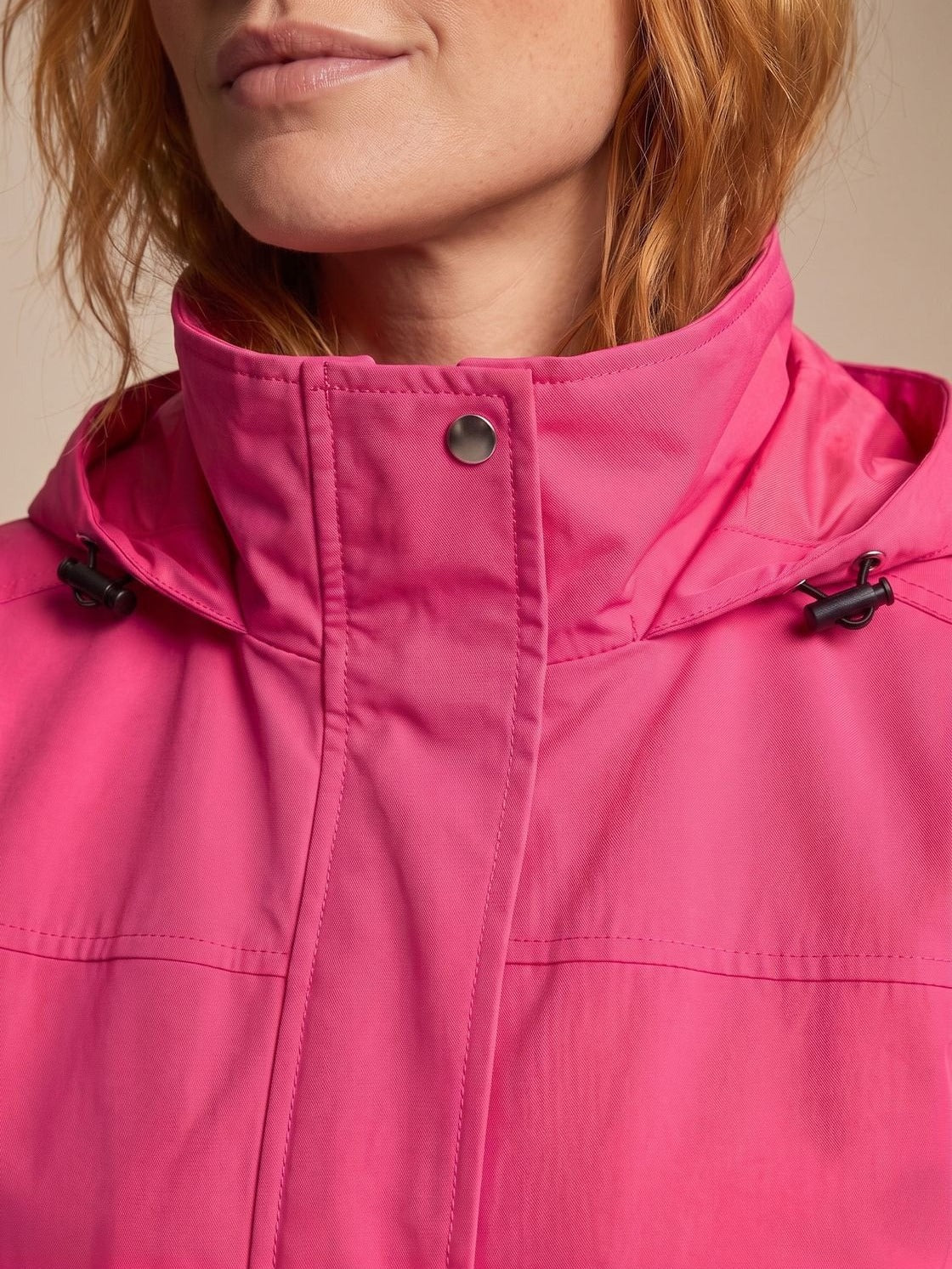 Close-up van de opstaande kraag, drukknoopsluiting en capuchonkoord | Boutique Moda