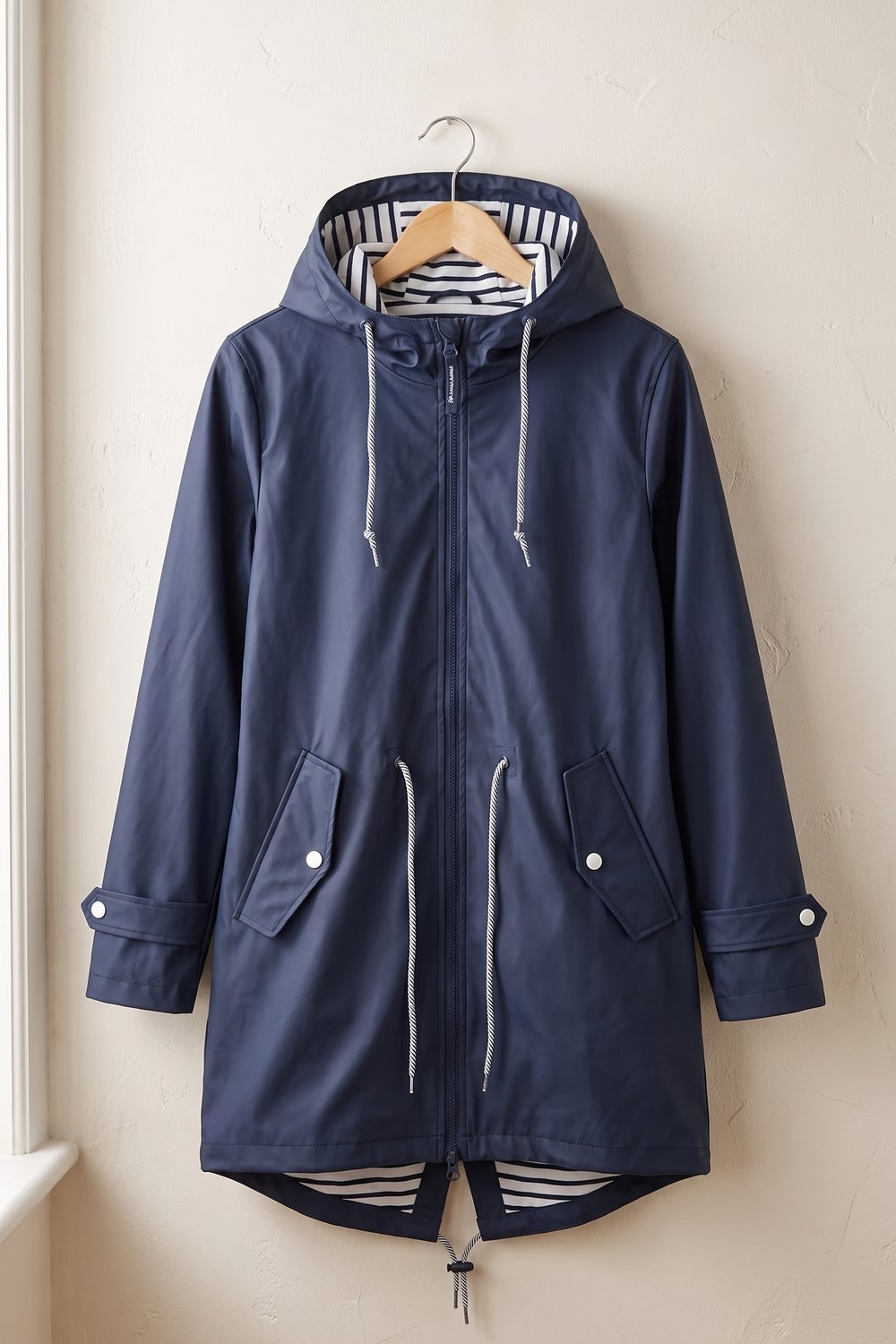 Marineblauwe regenjas met capuchon aan een hanger, voorkant