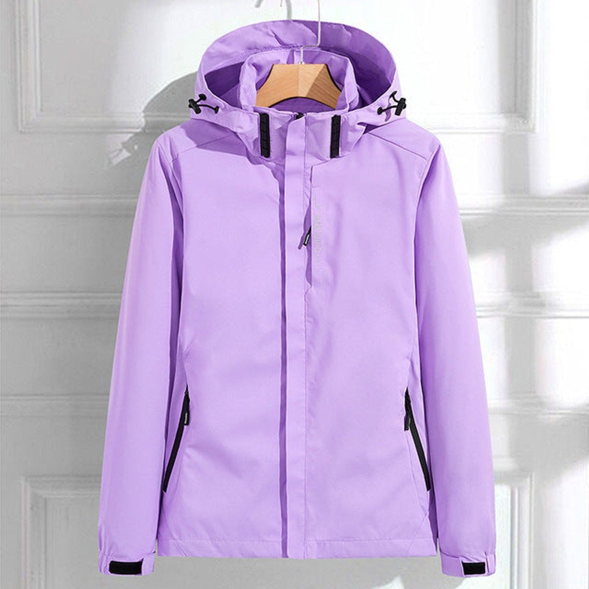 Lila waterdicht windjack met capuchon en ritszakken met zwarte rand, aan een kledinghanger | Boutique Moda