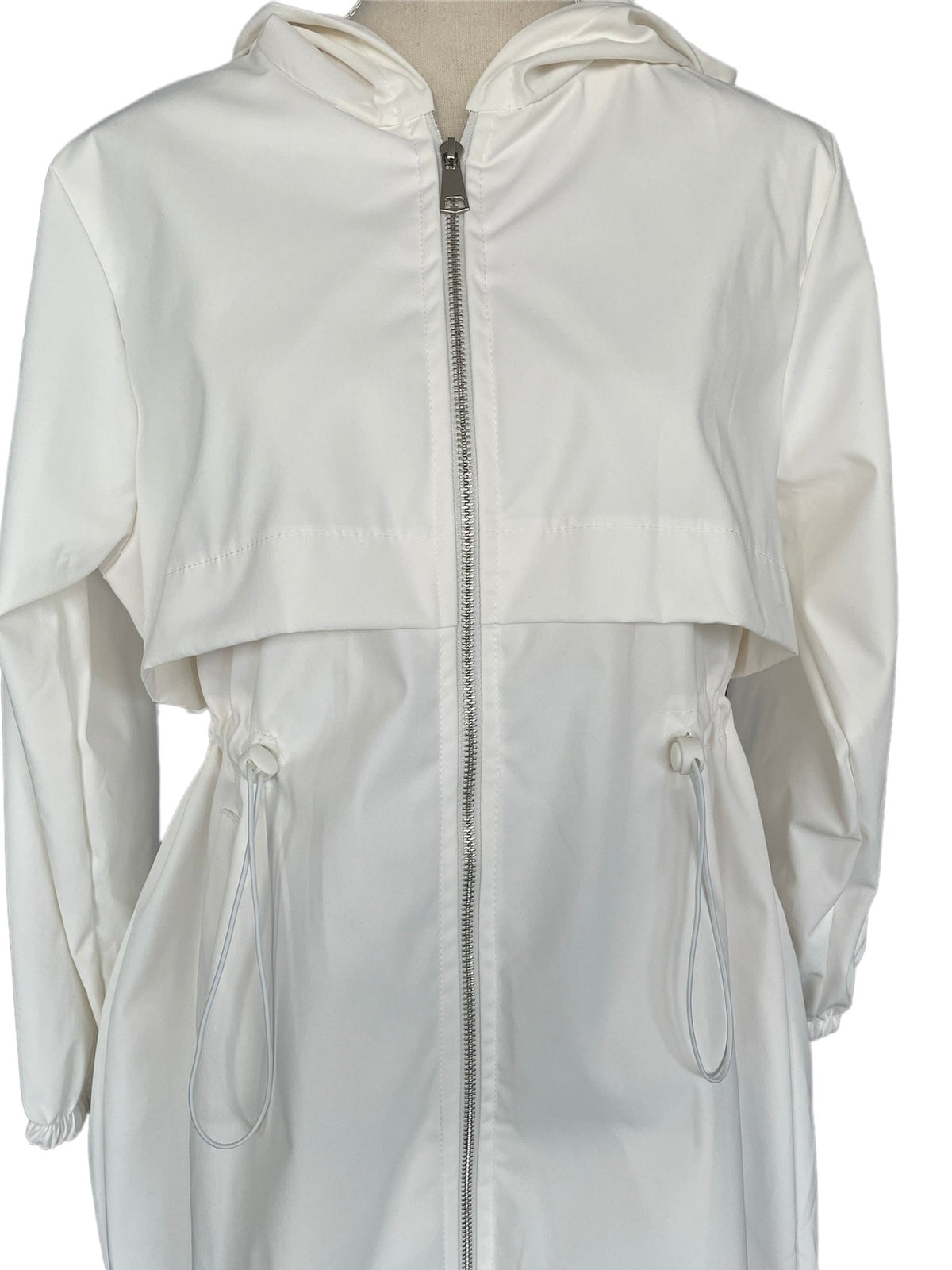 Close-up van de witte regenjas met rits, pas en taillekoorden | Boutique Moda
