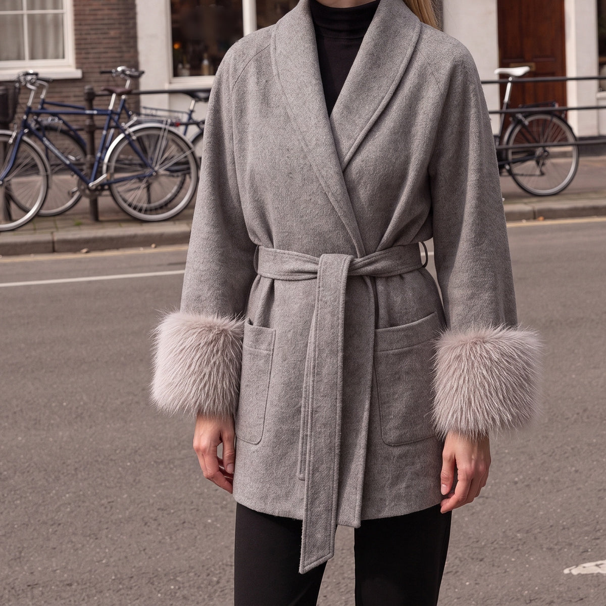 Wikkeljas in grijs met nepbont manchetten en strikceintuur | Boutique Moda