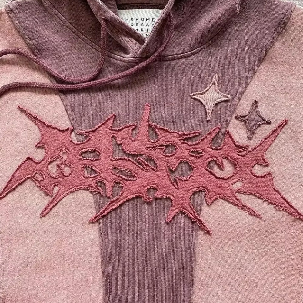 Close-up van de gotische patch met rafelrand en de sterren op de roze hoodie | Boutique Moda